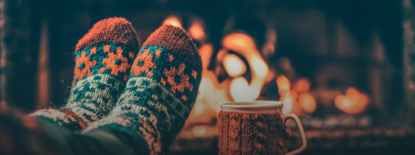 How-to-reach-tech-support-holidays-2023-banner-Image showing cozy socks by a fire
