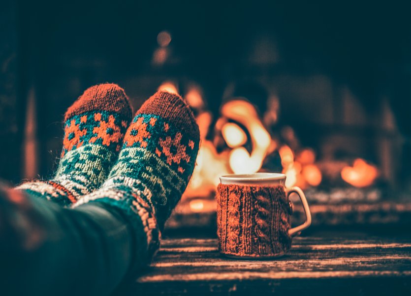 How-to-reach-tech-support-holidays-2023-main-Image showing cozy socks by a fire