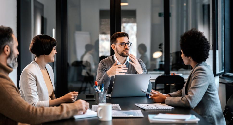 Custom upgraded - Group of coworkers sitting in a boardroom, having a discussion