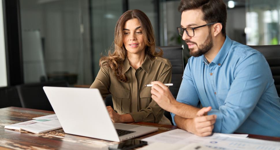 Guided digital upgrade - man and woman sitting at a desk, looking at a computer together