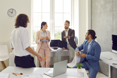 A group of people talking in an office. 