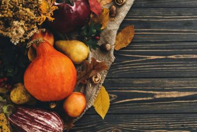 A collection of Thanksgiving gourds on a wooden table. 