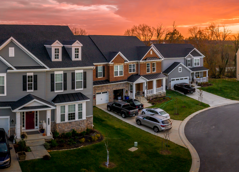 A house in a suburban neighborhood while the sun sets. 